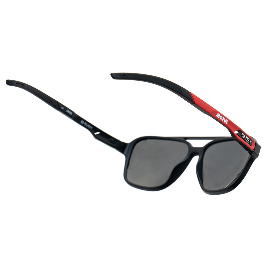 Schwarze Sonnenbrille mit grauen Gläsern und rotem Akzent. Rudy Project und Motul.