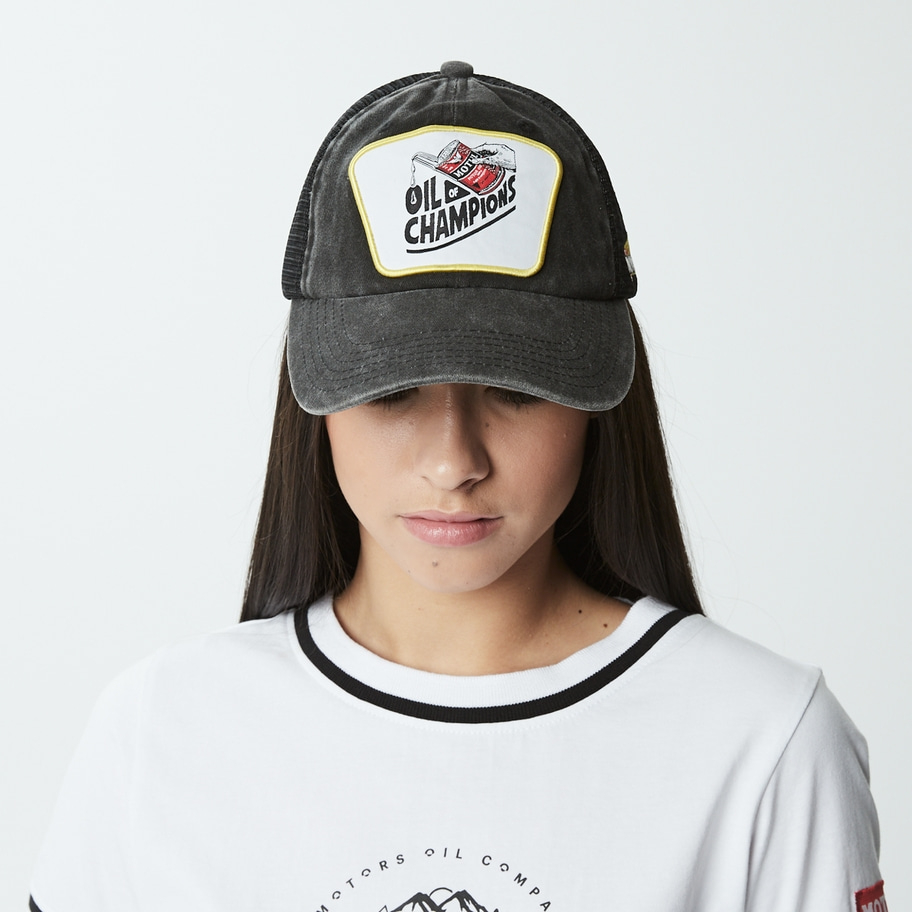 Frau trägt eine schwarze Trucker-Cap mit einem Logo, weißes T-Shirt, Nahaufnahme