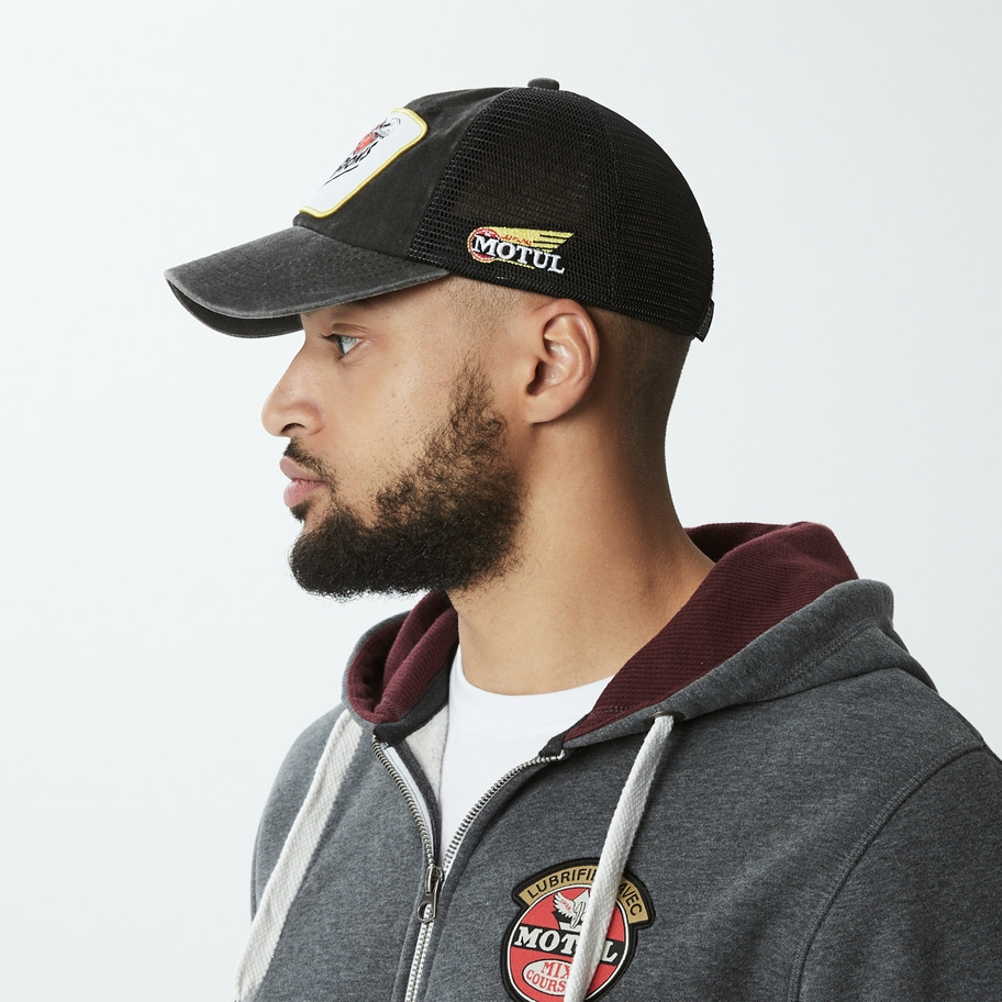 Mann mit Mütze und Kapuzenjacke, Motul-Logo, Seitenansicht, Bart, graue Kleidung