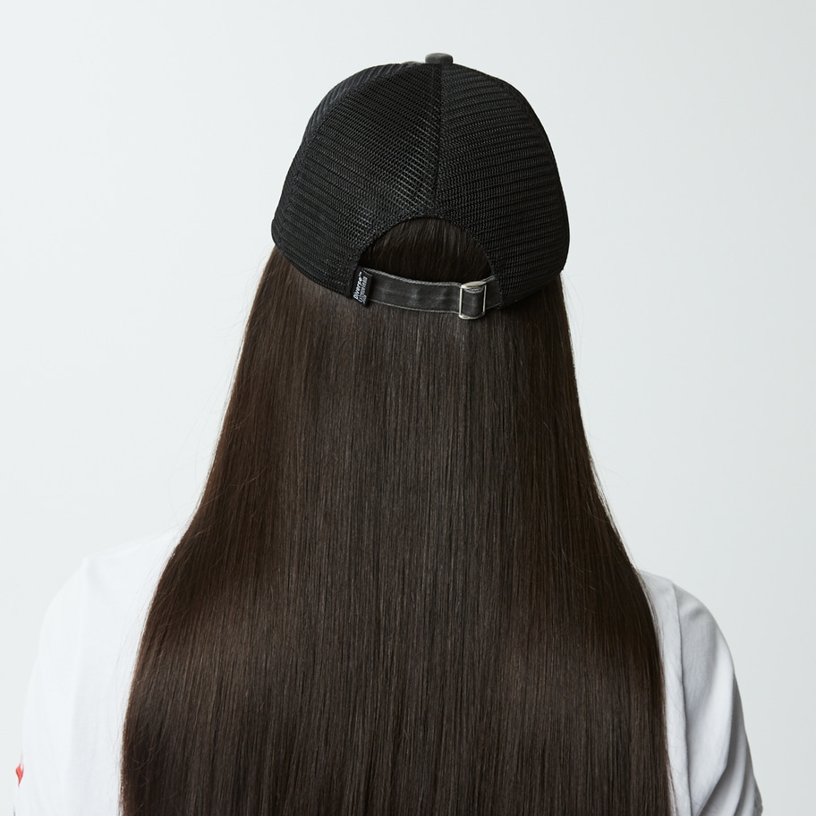 Rückansicht einer Person mit langen, dunklen Haaren und einer schwarzen Kappe